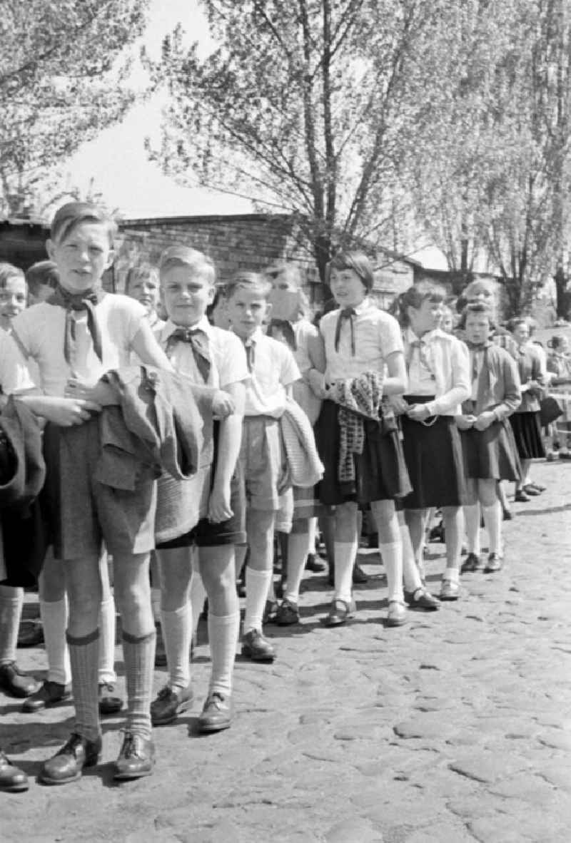 Junge Pioniere in Pionierkleidung und Halstuch versammeln sich vor ihrer Schule in Leipzig, um geschlossen an der Demonstration zum 1. Mai 1957 teilzunehmen.