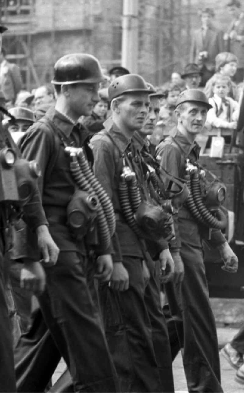 Mitglieder der gerade erst zwei Jahre alten Nationalen Volksarmee nehmen mit Kampfanzug und Gasmaske an der Demonstration zum 1. Mai 1958 in Leipzig.