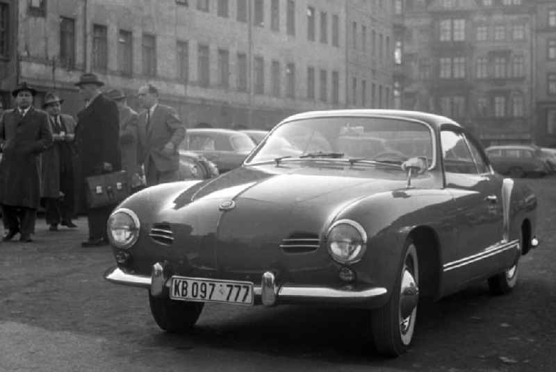Zur Leipziger Frühjahrsmesse parkt ein Westauto, ein VW Karmann-Ghia Typ 14, im Zentrum der Messestadt. Das Autokennzeichen auf dem Nummernschild 'KB' deutet auf die Herkunft des Wagens - 1947 war von der Alliierten Kommandatur der Stadt Berlin eine Änderung des 1945 eingeführten Kennzeichens 'BG' für 'Berlin Gorod' (russisch: Berlin Stadt)in das KFZ-Kennzeichen 'KB' für 'Kommandatura Berlin' verfügt worden. 1956 wurde für West-Berlin nach und nach das 'B' eingeführt, in Ost-Berlin gab es bereits seit 1948 das 'GB', seit 1953 das 'I'.