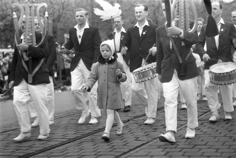 Angeführt von einem Mädchen mit einer weißen Friedenstaube in der Hand, nimmt ein Musikkorps an der Demonstration zum 1. Mai 196
