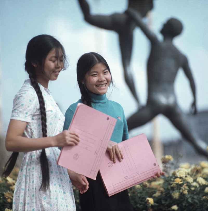 Junge Vietnamesinnen posieren mit ihren Unterlagen für den Fotografen. Vietnamesen bildeten in der DDR die größte Gruppe an Arbeitskräften aus den sozialistischen Bruderländern.