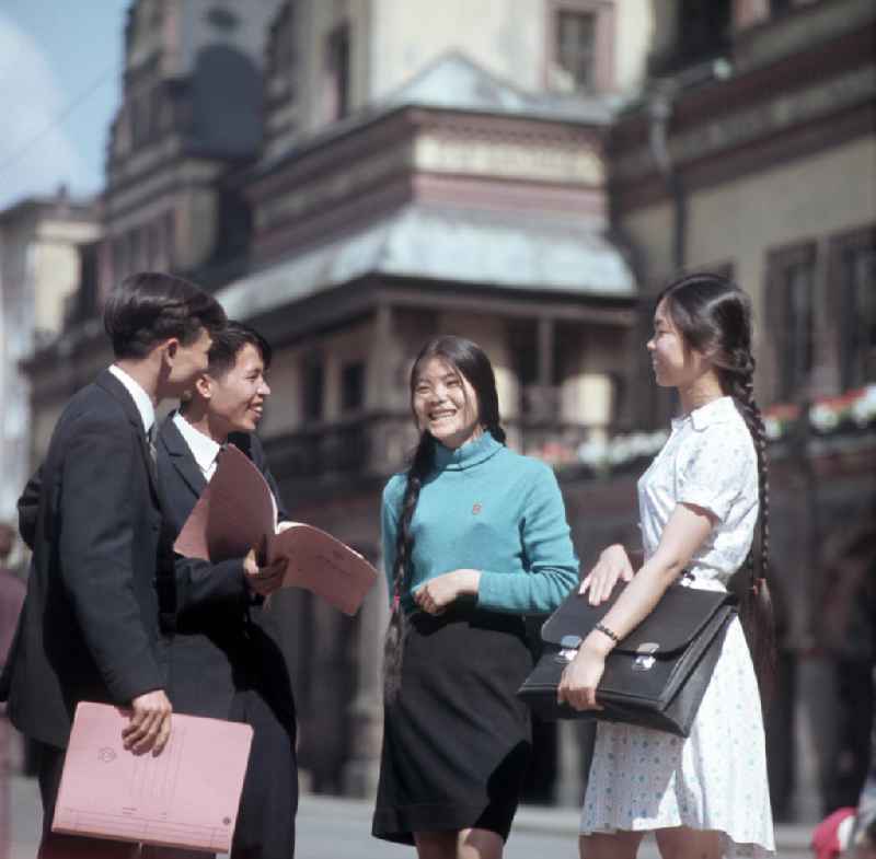 Junge Vietnamesen stehen in einer Pause auf der Straße. Vietnamesen bildeten in der DDR die größte Gruppe an Arbeitskräften aus den sozialistischen Bruderländern.