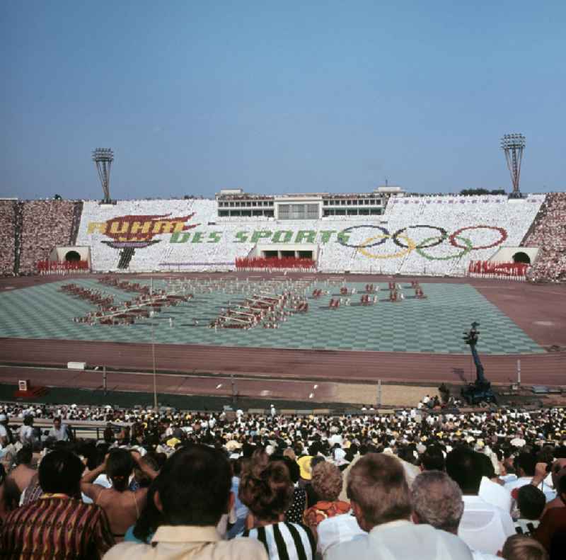 Für die Sportschau zum V. Turn- und Sportfest der DDR vom 24. bis 27.7.1969 in Leipzig gestalten die Teilnehmer im Leipziger Zentralstadion eine Veranstaltung mit Tribünenbildern und Aktionen. Die Losung lautet: 'Ruhm des Sports'.