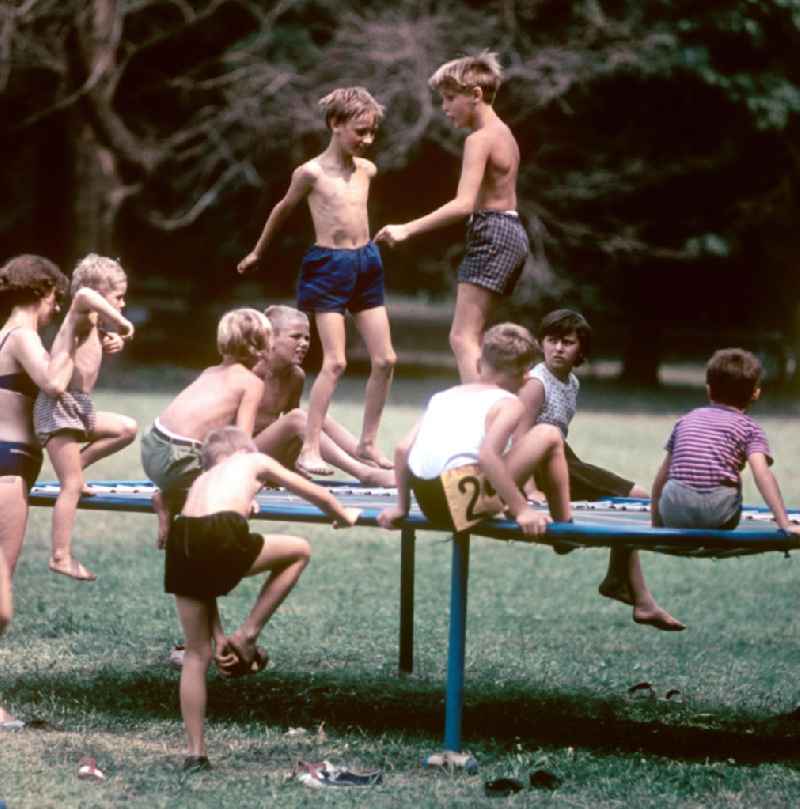 Kinder hüpfen auf einem Trampolin am Rande des V. Turn- und Sportfestes der DDR vom 24. bis 27.7.1969 in Leipzig.
