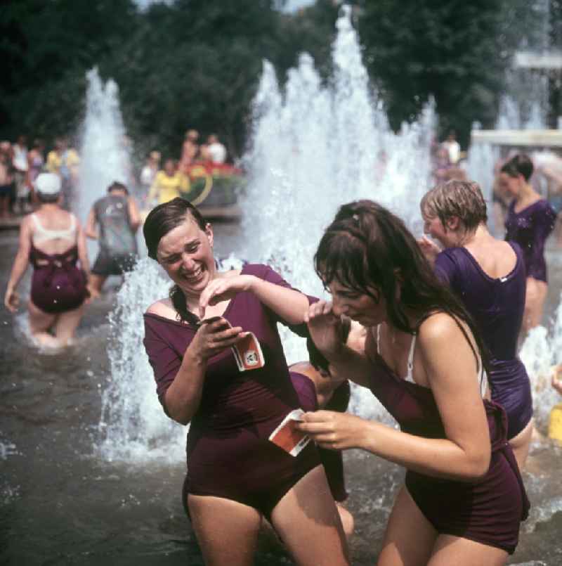 Am Rande des V. Turn- und Sportfestes der DDR vom 24. bis 27.7.1969 in Leipzig kühlen sich junge Turnerinnen in einem Springbrunnen ab.