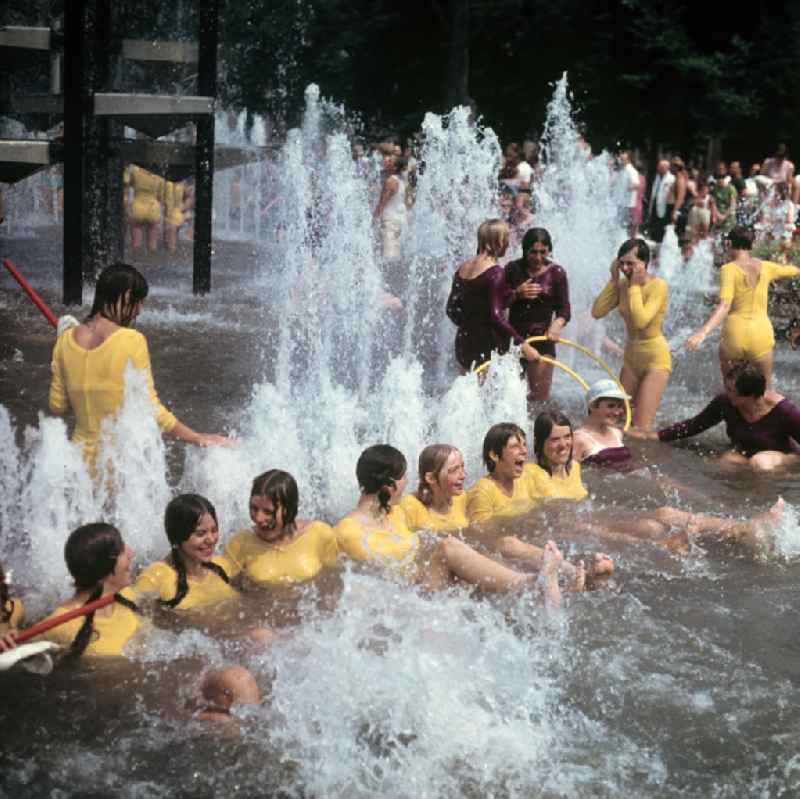 Am Rande des V. Turn- und Sportfestes der DDR vom 24. bis 27.7.1969 in Leipzig kühlen sich junge Turnerinnen in einem Springbrunnen ab.