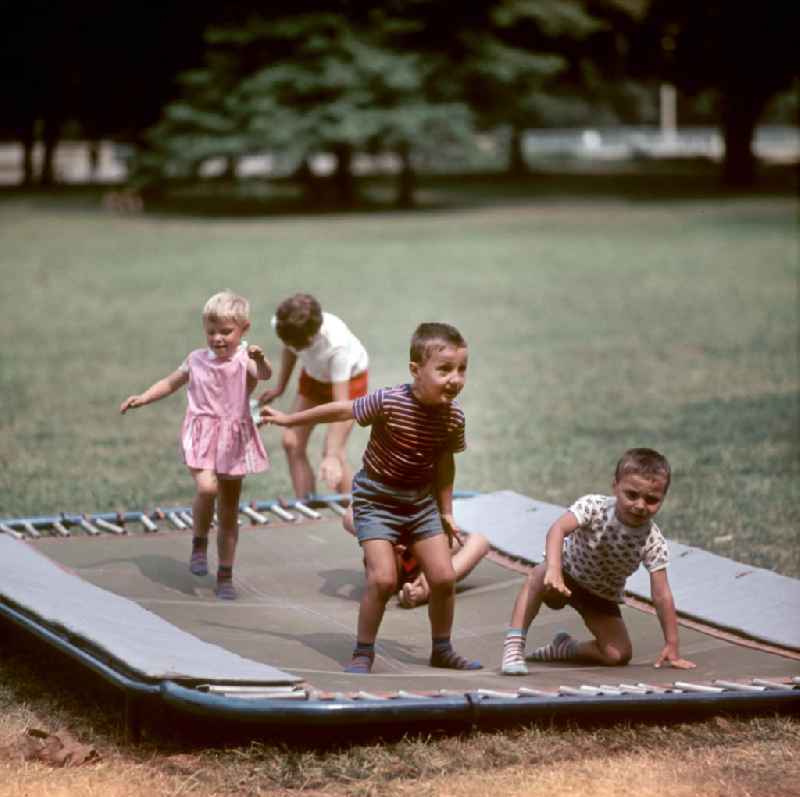 Kinder üben an Sportgeräten am Rande des V. Turn- und Sportfestes der DDR vom 24. bis 27.7.1969 in Leipzig.