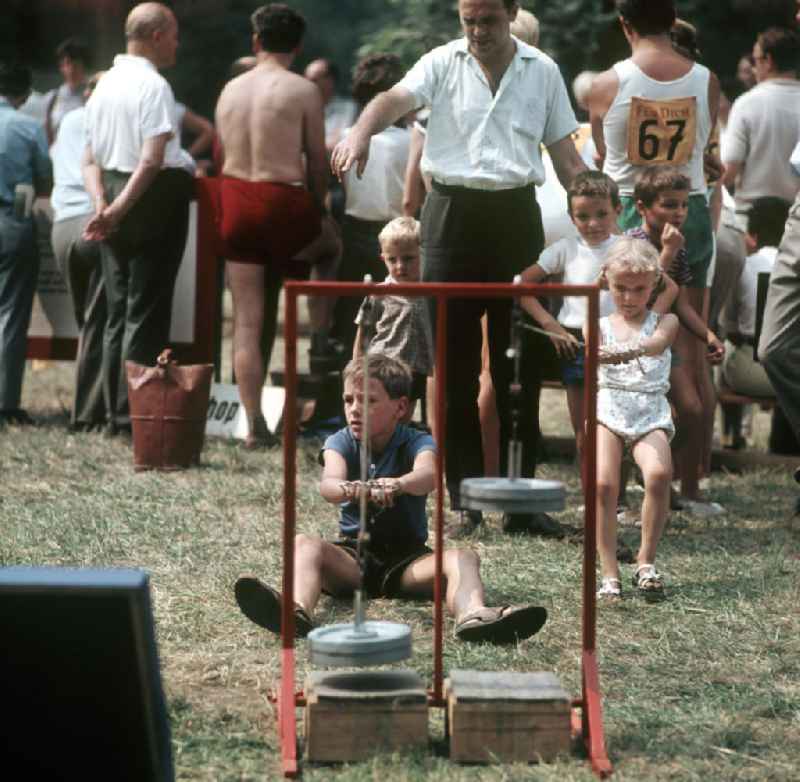 Kinder üben an Sportgeräten am Rande des V. Turn- und Sportfestes der DDR vom 24. bis 27.7.1969 in Leipzig.