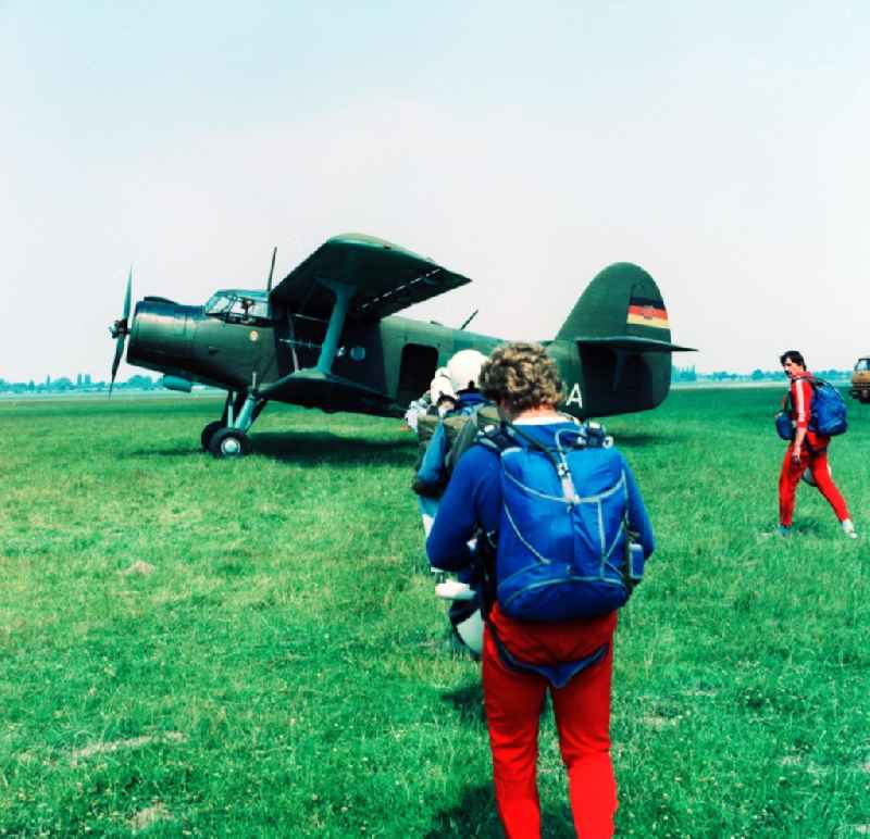 An aircraft of type Antonov An-2 and paratroopers on the GST airfield in Leipzig-Mockau in Saxony in the area of the former GDR, German Democratic Republic