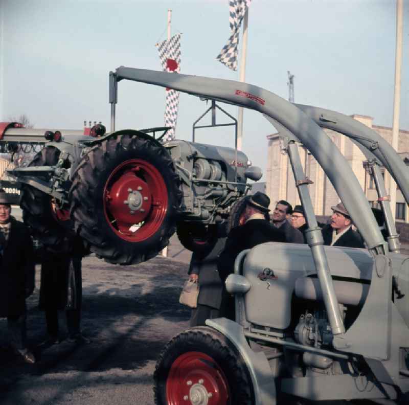 Visitors are interested in agricultural machinery and tractors on the open area of the Leipzig fair in Leipzig in the federal state Saxony in the area of the former GDR, German democratic republic