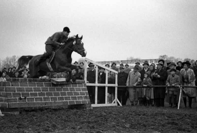 Rider jumps with his horse over a wall during the riding and driving competition at the Scheibenholz racecourse in Leipzig in the state Saxony on the territory of the former GDR, German Democratic Republic