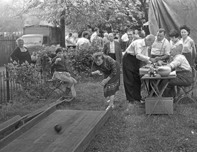 Young and old have a lot of fun bowling at an allotment garden site in Leipzig in the state Saxony on the territory of the former GDR, German Democratic Republic