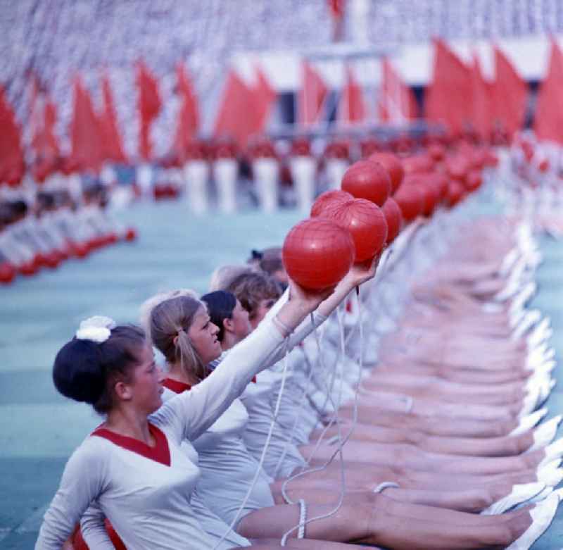 Athletes at the opening ceremony in Leipzig's Central Stadium during the V. Gymnastics and Sports Festival of the GDR in the district Mitte in Leipzig in the state Saxony on the territory of the former GDR, German Democratic Republic. They are performing gymnastic exercises with red balls