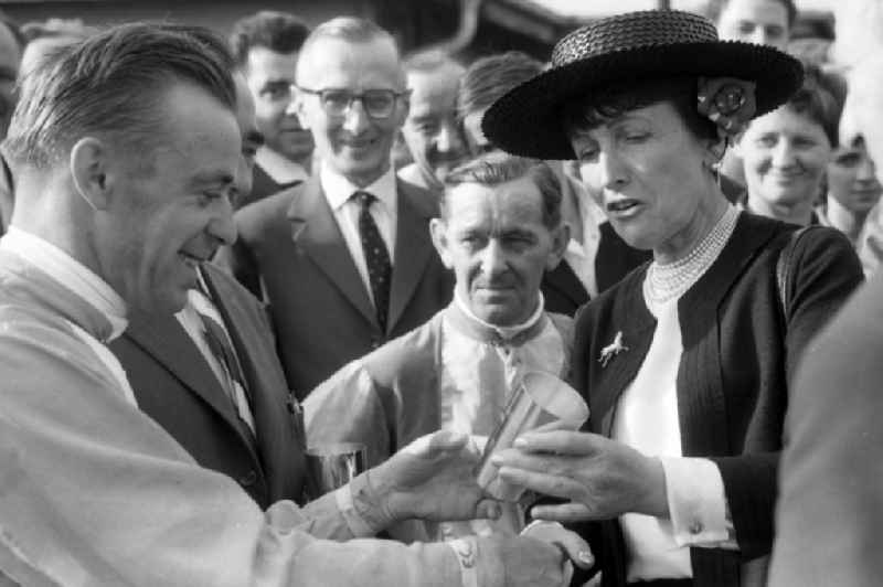 Maria Mehl-Muelhens presents jockey Egon Czaplewski with an honorary prize in Leipzig in the state Saxony on the territory of the former GDR, German Democratic Republic