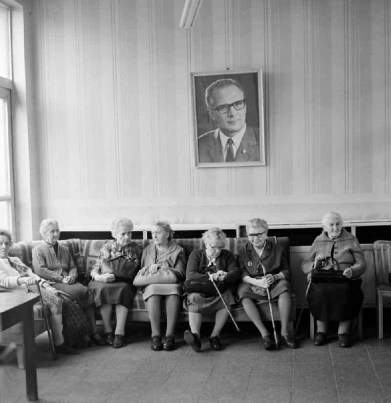 Senior citizens sit under a portrait of Erich Honecker in the Andersen-Nexoe-Heim in Leipzig in the federal state of Saxony on the territory of the former GDR, German Democratic Republic