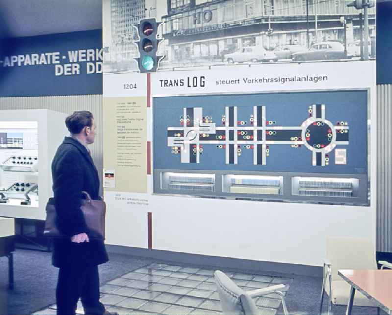 Visitors on the occasion of the exhibition 'Green Wave traffic light control panel' at the Leipzig Trade Fair in Leipzig, Saxony on the territory of the former GDR, German Democratic Republic. The development department of the EAW VEB Elektro-Apparate-Werke developed an electronic control of the traffic light regulation for a 'green wave'. The vocational school is building a demonstration board that was exhibited at the Leipzig Trade Fair. The control was carried out with the factory's own digital Translog and Transresch modules