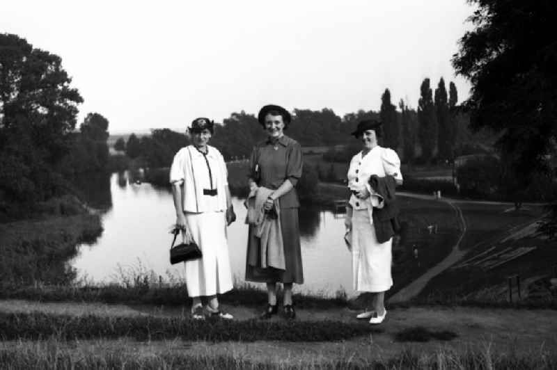 Three women go for a Sunday walk in Leuna in the federal state Saxony-Anhalt in Germany. In the background the Leuna works