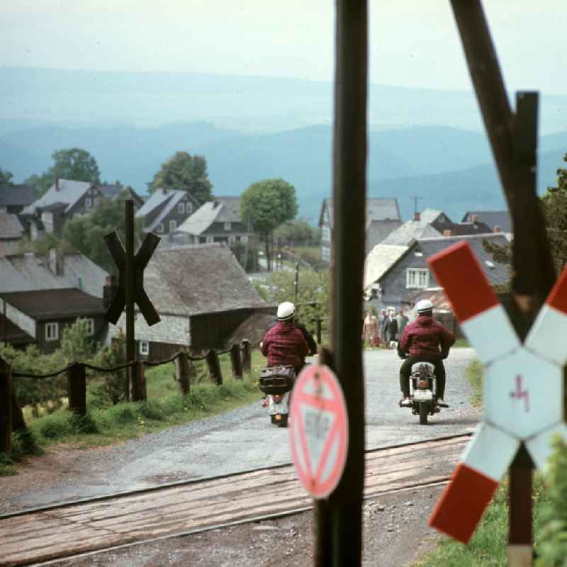 Motorräder überqueren den Bahnübergang bei Lichtenhain an der Bergbahn nahe Oberweißbach im Thüringer Wald. Der Thüringer Wald mit seinen Wander- und Erholungsmöglichkeiten war ein beliebtes Urlaubsziel in der DDR.