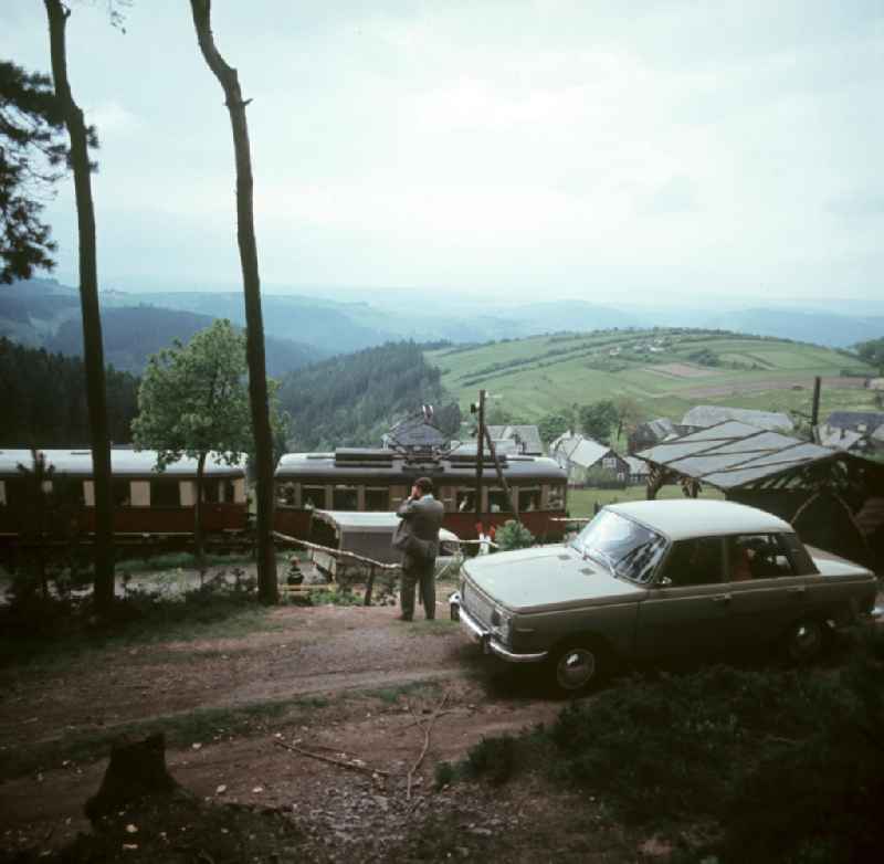Ein Mann fotografiert die Einfahrt der Bergbahn in die Bahnstation von Lichtenhain nahe Oberweißbach im Thüringer Wald. Der Thüringer Wald mit seinen Wander- und Erholungsmöglichkeiten war ein beliebtes Urlaubsziel in der DDR.