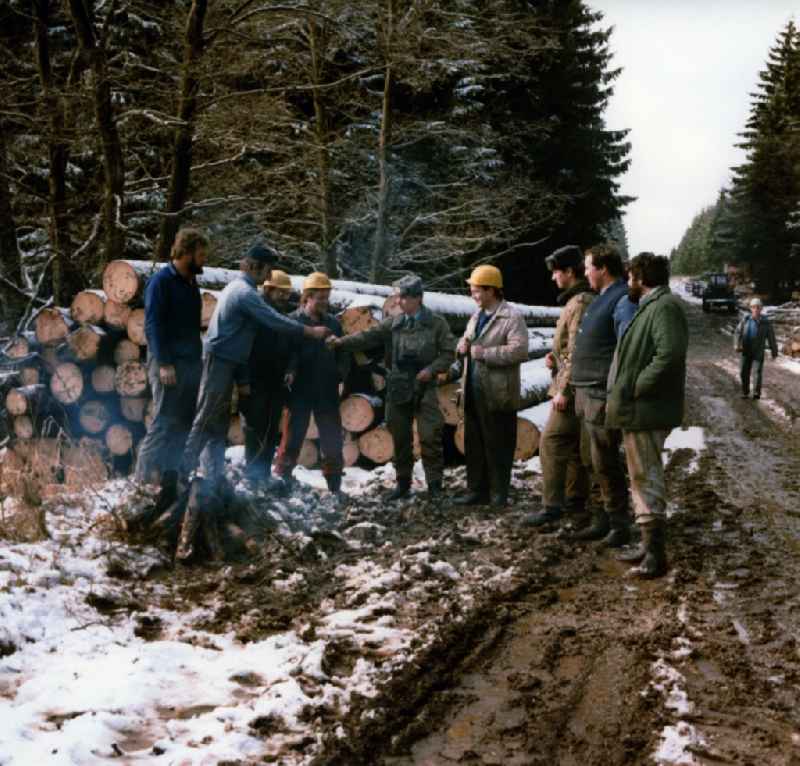 Border Patrol in snow in winter on the border strip in conversation with forestry workers in a wooded area near Lindewerra - Wahlshausen in present-day state of Saxony-Anhalt. The border guards of the border troops of the GDR - walls are equipped with AK-47 machine guns