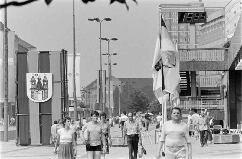 People stroll along Karl-Marx-Strasse (today Breiter Weg) in Magdeburg, Saxony-Anhalt in the area of the former GDR, German Democratic Republic. Everything is festively decorated on the occasion of the 21st Workers' Festival