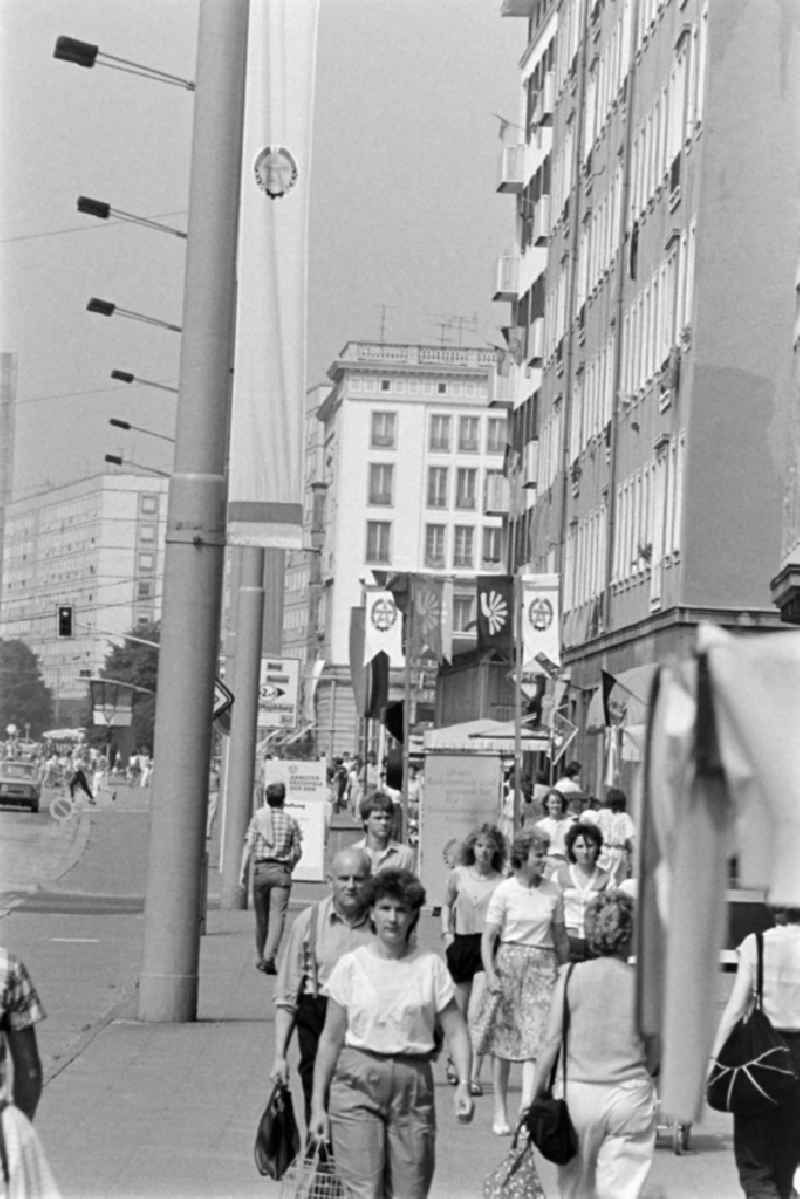 People stroll along Karl-Marx-Strasse (today Breiter Weg) in Magdeburg, Saxony-Anhalt in the area of the former GDR, German Democratic Republic. Everything is festively decorated on the occasion of the 21st Workers' Festival