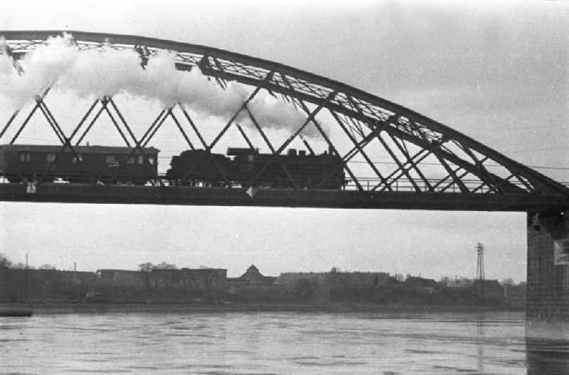 Ein fahrender Zug mit Dampflok auf der Herrenkrugbrücke / Herrenkrug-Eisenbahnbrücke. Unter der Brücke die Elbe. Bestmögliche Qualität nach Vorlage!