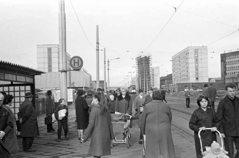 Waiting passersby at a tram stop on the Broad way in Magdeburg. The way width is the main commercial street in Magdeburg. In the background of the site is to see 'Teacher's House'. In the time of the GDR width way Karl-Marx-Straße was called