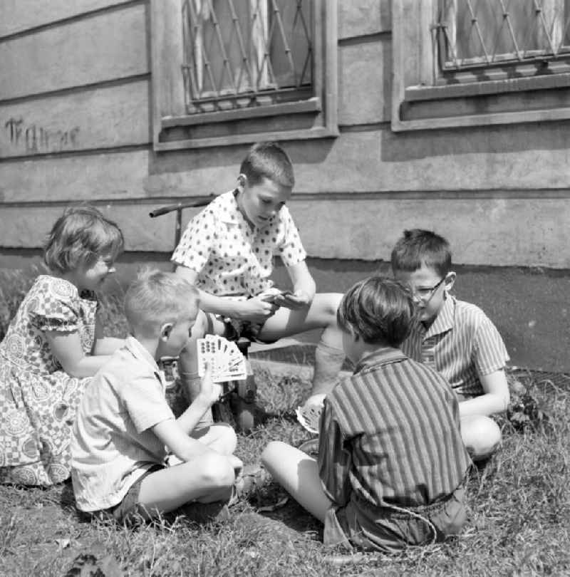 Children playing cards outdoors in Magdeburg
