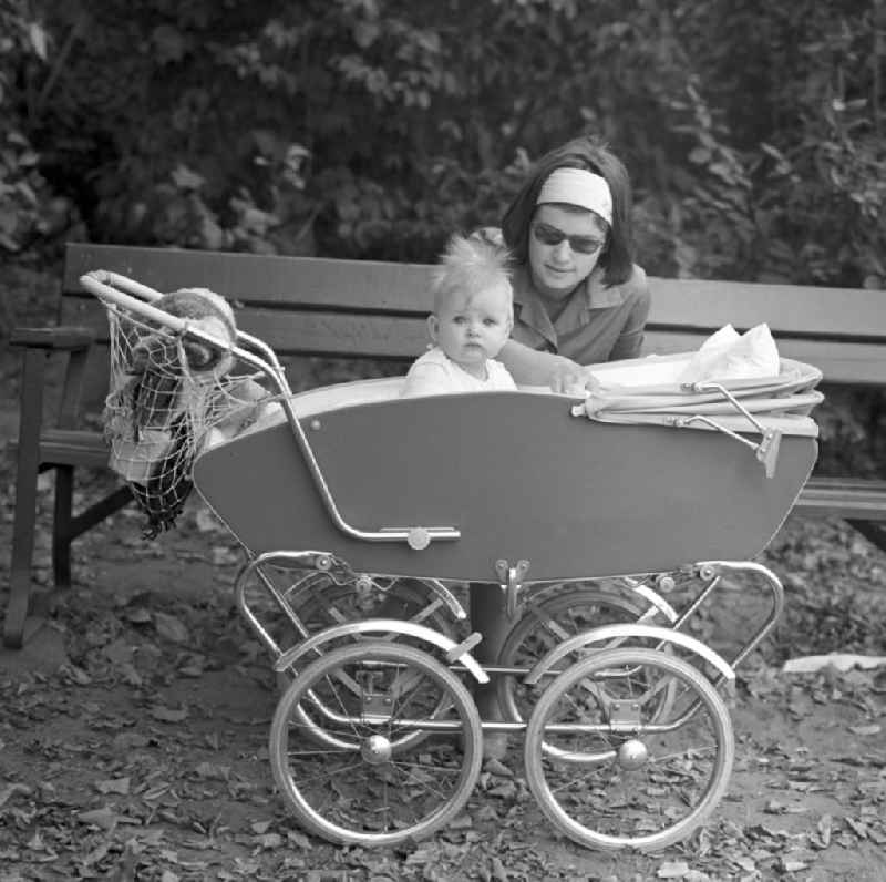 A mother with her baby in a stroller in the city park of Magdeburg
