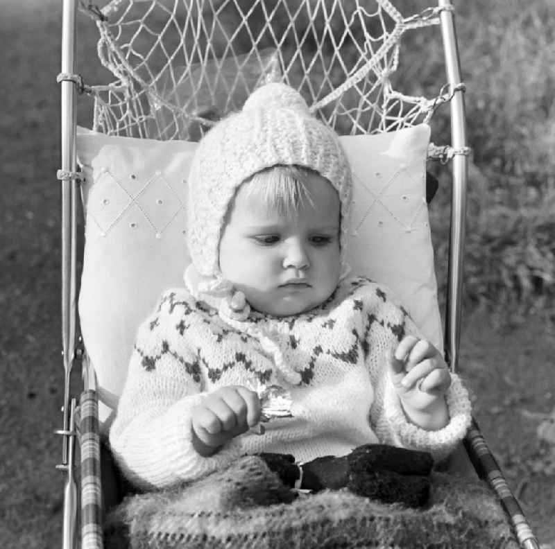 Small child with bobble hat sitting in a pram in Magdeburg