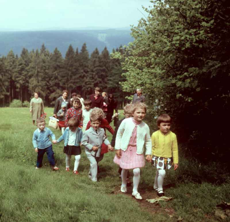 Kinder und Frauen gehen im Thüringer Wald bei Masserberg spazieren, zum Pfingstfest tragen sie festliche Kleidung. Der Thüringer Wald mit seinen Wander- und Erholungsmöglichkeiten war ein beliebtes Ausflugs- und Urlaubsziel in der DDR.