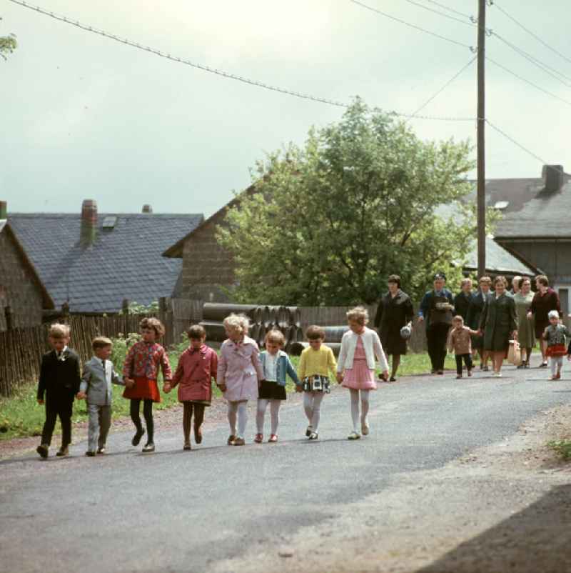 Kinder und Frauen gehen in Masserberg im Thüringer Wald spazieren, zum Pfingstfest tragen sie festliche Kleidung. Der Thüringer Wald mit seinen Wander- und Erholungsmöglichkeiten war ein beliebtes Ausflugs- und Urlaubsziel in der DDR.