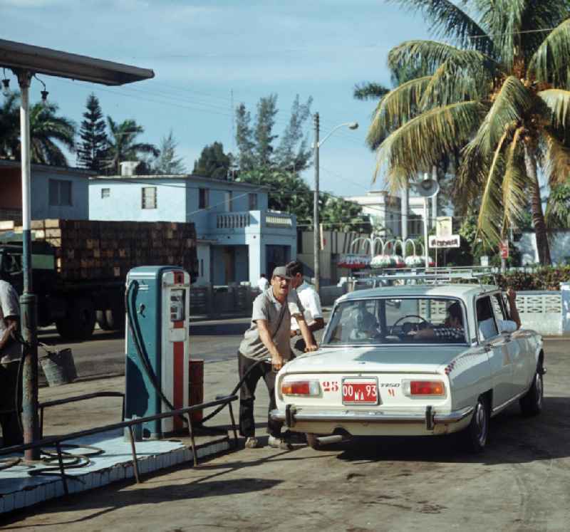 Straßenszene in Matanzas - Kuba. Tankwart  betankt einen Alfa Romeo 175