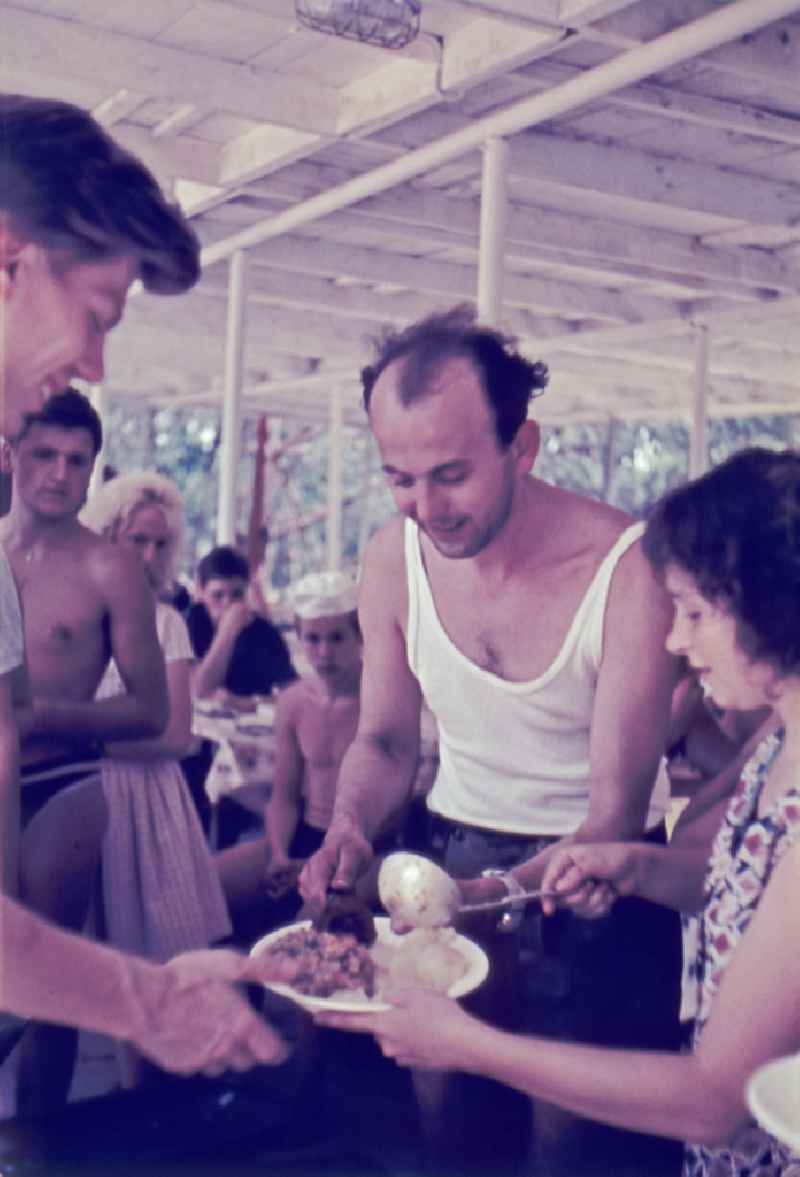 Summer camp operation with pupils and teenagers at lunch - food distribution in Menz, Brandenburg on the territory of the former GDR, German Democratic Republic