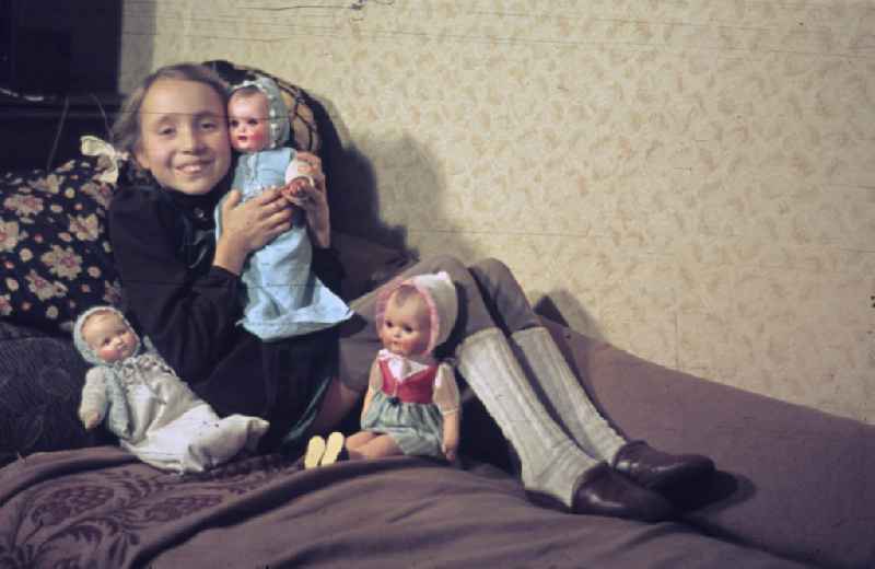 Weihnachten in der Nachkriegszeit. Ein Mädchen spielt mit Puppen an Heiligabend. Christmas in the postwar period. A girl plays with Dolls at the Christmas Eve.