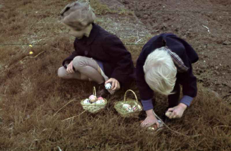Kinder sammeln Ostereier auf einer Wiese zu Ostern in Mersburg. Children at Easter egg hunt.