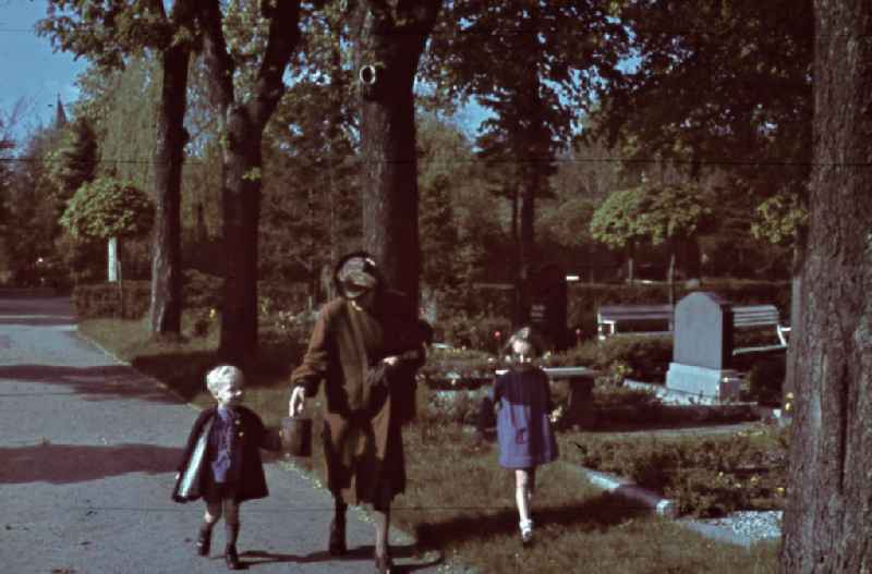 Mutter mit Kindern auf einem Friedhof in Merseburg. Mother with children at a cemetery in Merseburg.