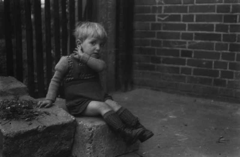 Ein Junge spielt im Hinterhof. A boy is plying in a backyard.