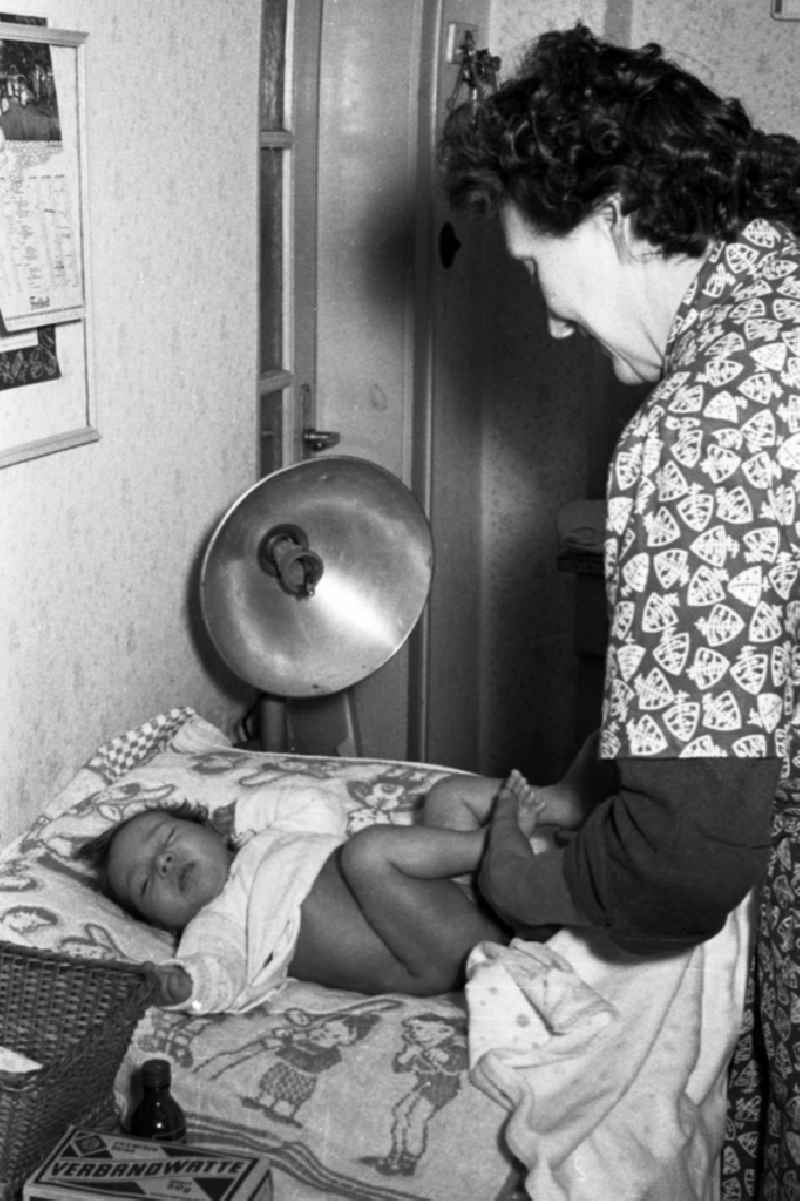 A mother wraps her baby in Merseburg in the federal state Saxony-Anhalt in the area of the former GDR, German democratic republic