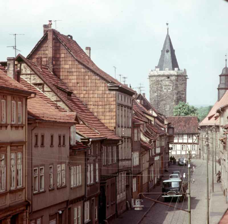 Blick durch die Holzstraße mit ihren historischen Altbauten auf den Rabenturm an der Stadtmauer von Mühlhausen.