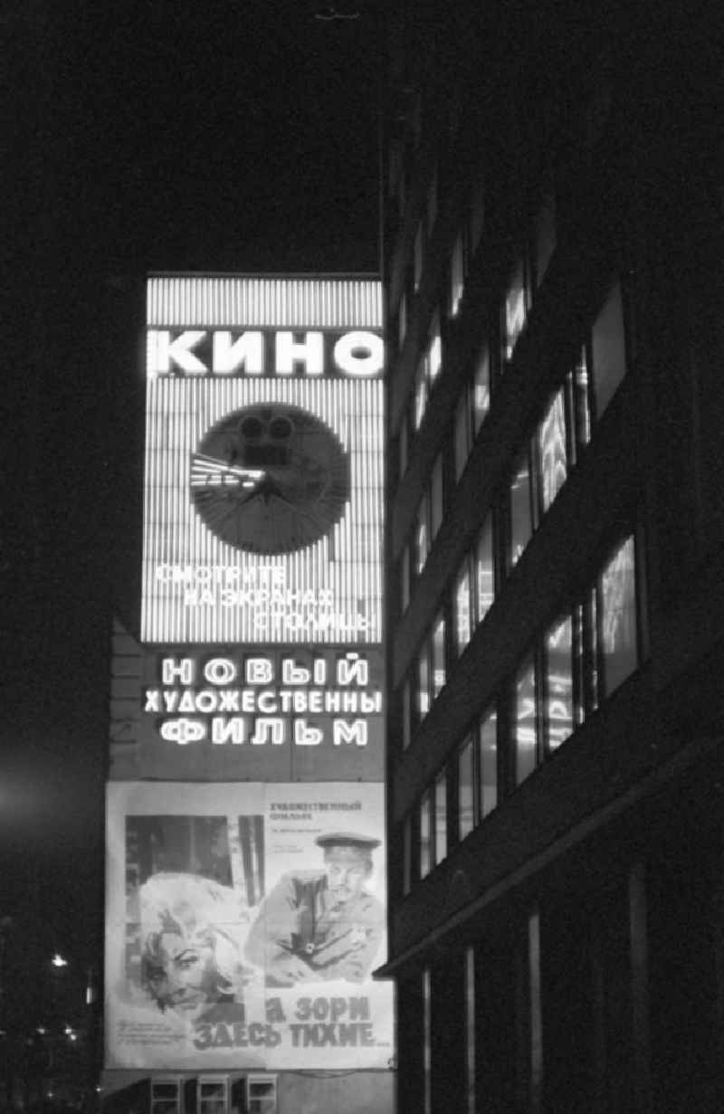 Nachtaufnahme: Leuchtreklame und Filmwerbung an einem Kino am Roten Platz in Moskau.
