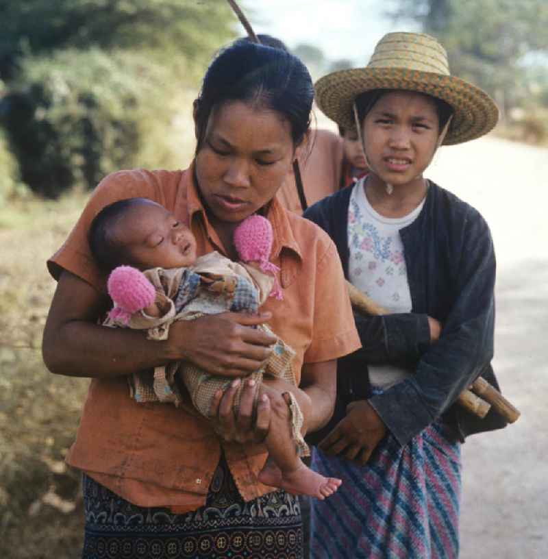 Eine Frau hält ihr Baby auf dem Arm am Fluß Nam Ngum in der Demokratischen Volksrepublik Laos.