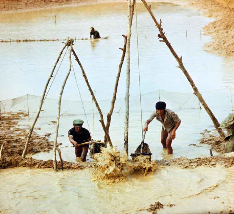 Männer beim Fischfang am Fluß Nam Ngum in der Demokratischen Volksrepublik Laos.