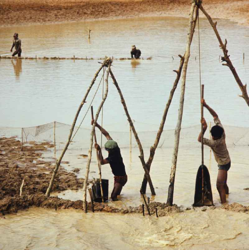 Männer beim Fischfang am Fluß Nam Ngum in der Demokratischen Volksrepublik Laos.
