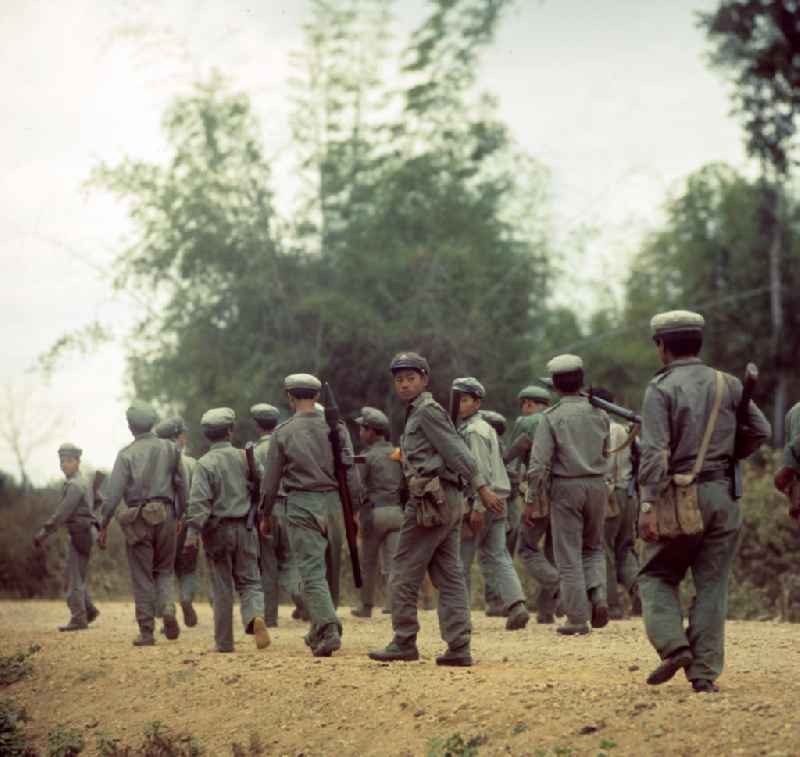 Soldaten der laotischen Armee in der Demokratischen Volksrepublik Laos. Erst ein Jahr zuvor, am 2. Dezember 1975, war durch die kommunistisch geprägten Kräfte die Volksrepublik Laos ausgerufen worden. Die politische und wirtschaftliche Situation blieb aber auch in den Folgejahren unsicher und instabil. Immer wieder kam es zu Rebellionen aus dem Hinterland, die mit Hilfe der Armee und ausländischer, v.a. vietnamesischer, Unterstützung gewaltsam niedergeschlagen wurden.