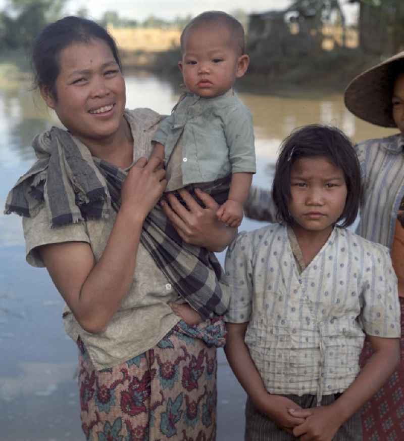 Eine Frau hält ihr Baby auf dem Arm am Fluß Nam Ngum in der Demokratischen Volksrepublik Laos.