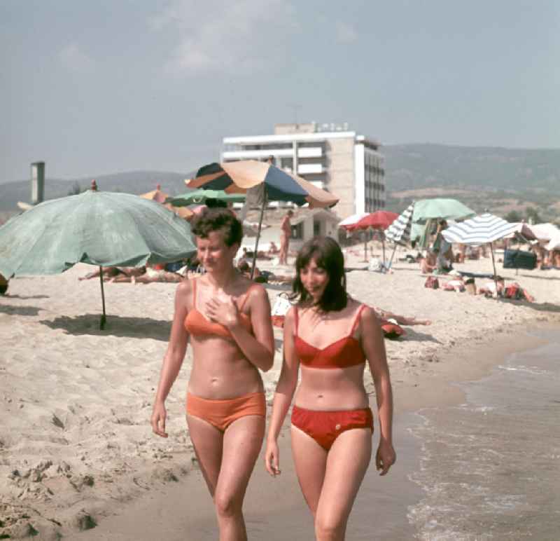 Junge Frauen laufen den Strand von Nessebar am Schwarzen Meer in der Volksrepublik Bulgarien entlang. Reisen in das Ausland war den DDR-Bürgern nur in die befreundeten sozialistischen Länder erlaubt, für Bulgarien erfolgte in der Regel die Erteilung einer Reisegenehmigung.