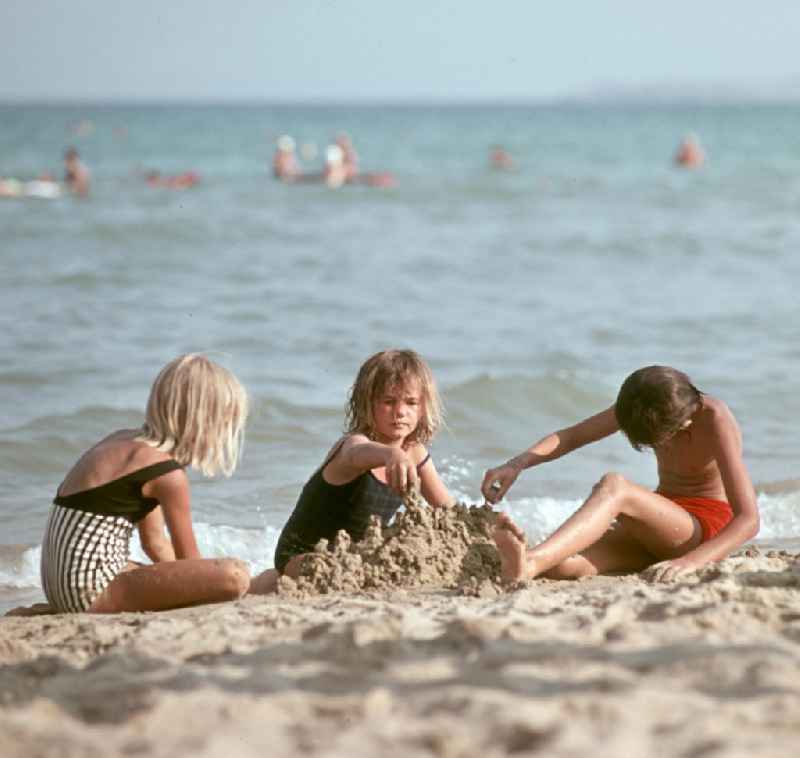 Kinder bauen eine Kleckerburg aus Sand am Strand von Nessebar am Schwarzen Meer in der Volksrepublik Bulgarien. Reisen in das Ausland war den DDR-Bürgern nur in die befreundeten sozialistischen Länder erlaubt, für Bulgarien erfolgte in der Regel die Erteilung einer Reisegenehmigung.