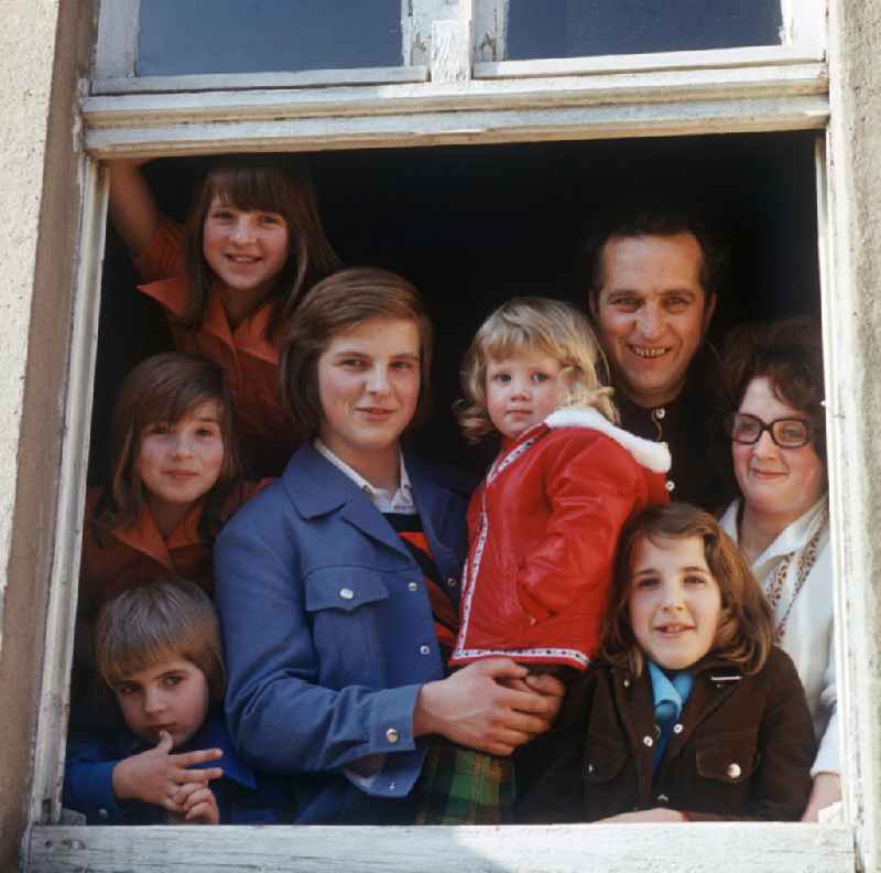 Eine kinderreiche Familie an einem Fenster in Neubrandenburg.